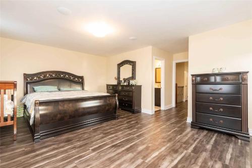 a bedroom with a bed and a dresser and a mirror at Jazzy Home Stay in Mississauga