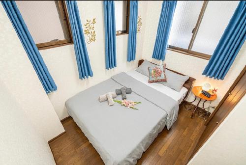 Habitación pequeña con cama con cortinas azules en 台東区寝室4つと広々吹き抜けリビングのメゾネットタイプのお家, en Tokio
