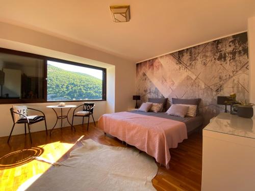 a bedroom with a bed and a large window at Rooms Paola in Mokošica