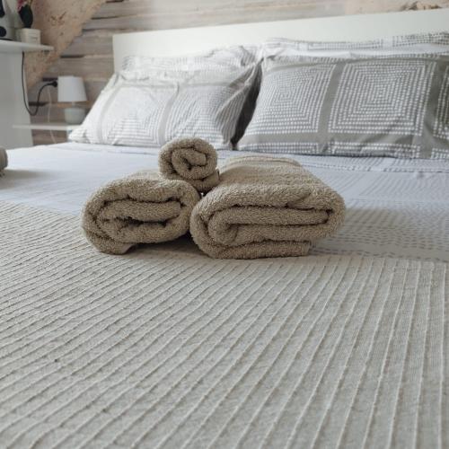 a bed with two towels on top of it at b&b Casa Balai 72 a 100 mt dal mare in Porto Torres
