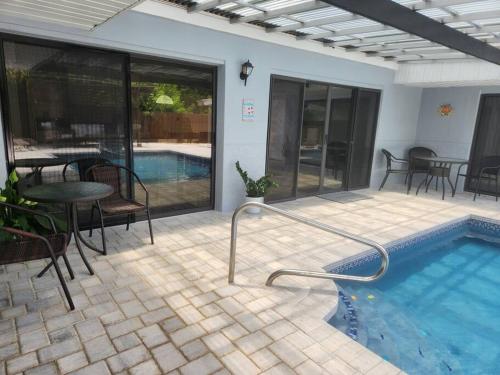 a patio with a pool and a table and chairs at Welcome to the Dolphin Den! in Largo