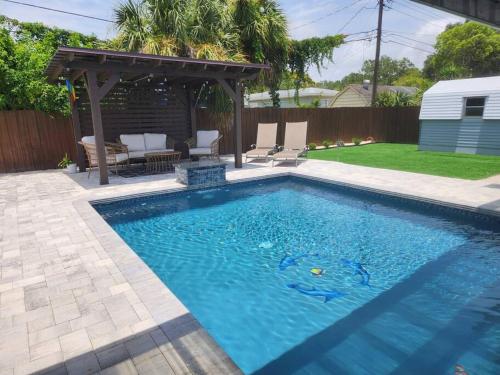 a swimming pool in a backyard with a gazebo at Welcome to the Dolphin Den! in Largo