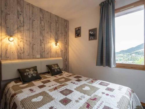 - une chambre avec un lit doté d'une couette et d'une fenêtre dans l'établissement Appartement rénové 2 pièces avec balcon à Valmorel, 4 pers, animaux acceptés - FR-1-291-842, à Valmorel