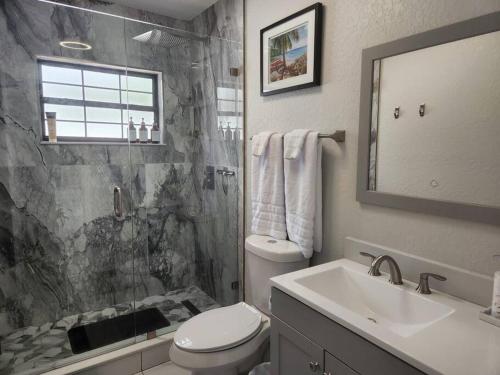 Un baño con inodoro, lavabo y ducha. en Welcome to the Dolphin Den!, en Largo