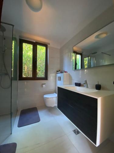 a bathroom with a sink and a toilet and a mirror at Rooms Paola in Mokošica