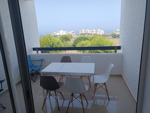 a white table and chairs on a balcony at Bel Appart Marina Golf Asilah in Asilah