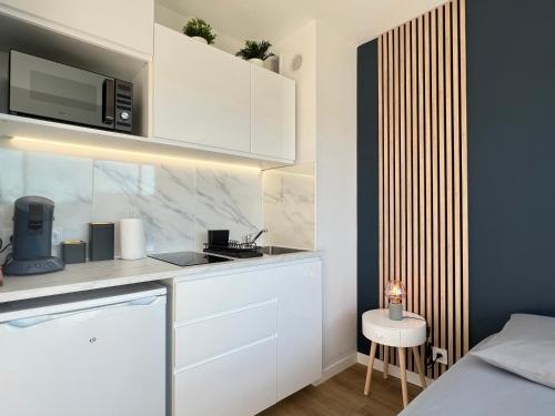 une cuisine blanche avec un évier et un micro-ondes dans l'établissement Studio Beaux Arts - *Proche centre *Clim *Balcon, à Montpellier