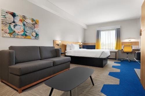 LachuteにあるMicrotel Inn & Suites by Wyndham Lachuteのソファとベッド付きのホテルルーム