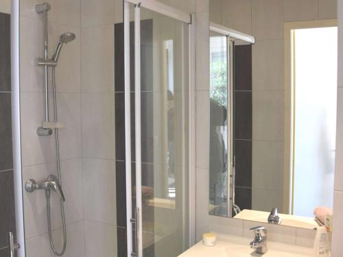 La salle de bains est pourvue d'une douche et d'un lavabo avec un miroir. dans l'établissement Marseillan Plage : Appartement 6 pers avec Terrasse, Parking et Option Internet - FR-1-387-159, à Marseillan