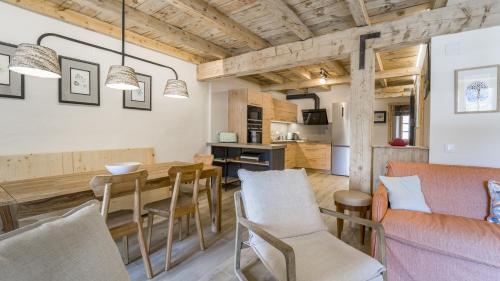 a kitchen and living room with a wooden table and chairs at Pleta del Tarter Lodge in El Tarter