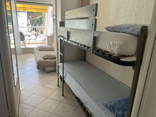 Cette chambre comprend 2 lits superposés et une terrasse couverte. dans l'établissement Studio climatisé 4 couchages avec piscine et parking, accès direct plage - Port Camargue - FR-1-250-162, au Grau-du-Roi