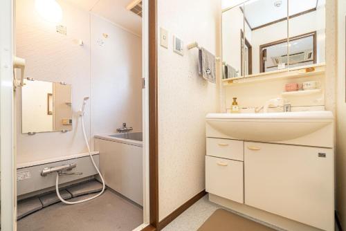 a bathroom with a sink and a mirror at 台東区広々吹き抜けリビングのメゾネットタイプのお家 in Tokyo