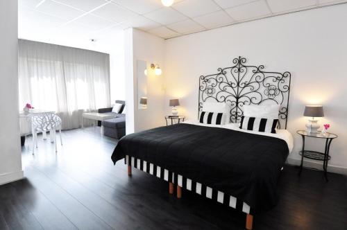 a bedroom with a black and white bed in a room at Hotel Zeespiegel in Zandvoort