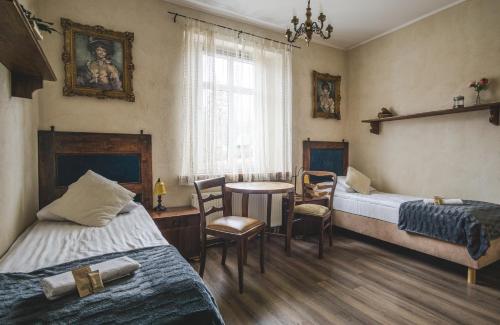pokój z 2 łóżkami, stołem i jadalnią w obiekcie Stara Willa w Jagniątkowie