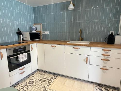 a kitchen with white cabinets and a sink at La Petite Ardoise - Maison au calme pour 4 pers in Honfleur