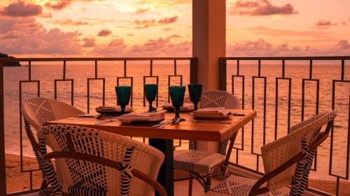 a wooden table with chairs and wine glasses on a balcony at La Puesta Sayulita in Sayulita