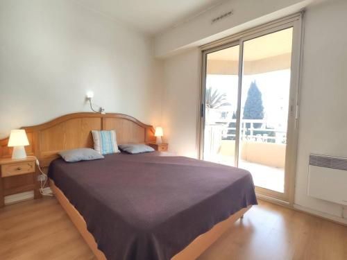 um quarto com uma cama grande e uma janela grande em Appartement Juan les Pins, 2 pièces, 4 personnes - FR-1-252-155 em Juan-les-Pins