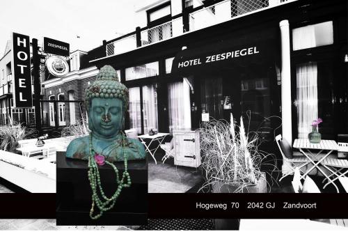 a statue of a buddha in front of a store at Hotel Zeespiegel in Zandvoort