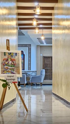 a painting on a stand in a room with chairs at Durrat Nizwa Inn in Nizwa