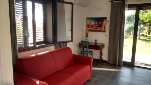 a living room with a red couch and a table at Avocado B&B Beyond in Giardini Naxos
