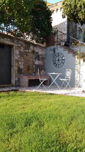 a building with a bench and a clock on it at Avocado B&B Beyond in Giardini Naxos