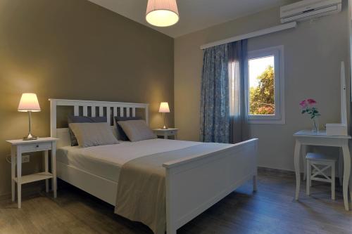 a bedroom with a white bed and a window at Villa Gaia in Dassia