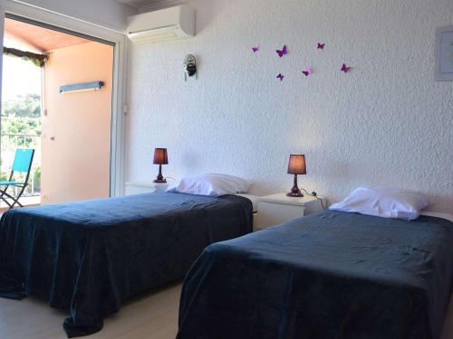 - 2 lits dans une chambre avec des papillons violets sur le mur dans l'établissement Appartement Banyuls-sur-Mer, 3 pièces, 6 personnes - FR-1-225C-57, à Banyuls-sur-Mer