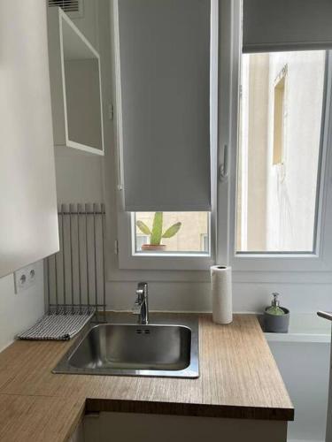 un comptoir de cuisine avec un évier et une fenêtre dans l'établissement Charmant studio rénové calme triangle d’Or Canal St Martin, à Paris