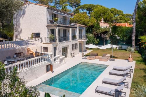 une vue extérieure d'une maison avec piscine dans l'établissement Villa Les Pins du Cap - Vue mer - Cap d'Antibes, à Antibes