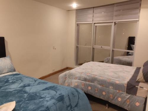 a bedroom with two beds and a large window at Hermoso departamento en La Paz-Bolivia in La Paz
