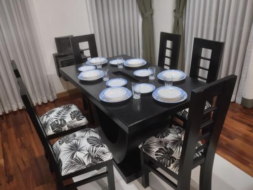 una mesa negra con platos y copas de vino. en Hermoso departamento en La Paz-Bolivia en La Paz