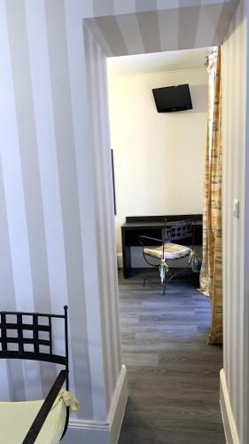a hallway with a room with a bed and a television at Hotel de la Basilique in Paray-le-Monial