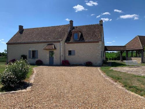 a large white house with a gravel driveway at Maison de charme en pleine nature in Saint-Germain-des-Grois