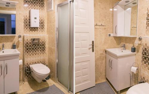 ein Bad mit einer Dusche, einem WC und einem Waschbecken in der Unterkunft Wohnung in Mahmutlar