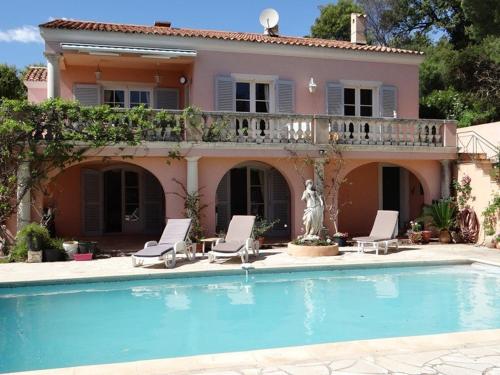 une maison avec une piscine devant une maison dans l'établissement Villa 4 chambres avec piscine et terrasses - FR-1-100-239, à Cavalaire-sur-Mer