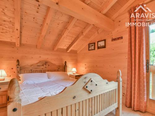 a bedroom with a bed in a log cabin at Chalet Le Grand-Bornand, 12 pièces, 20 personnes - FR-1-391-114 in Le Grand-Bornand