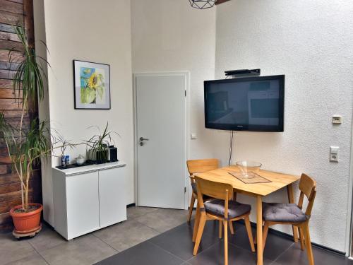 uma sala de jantar com uma mesa e uma televisão de ecrã plano em Apartment Finke 2 an der Messe Friedrichshafen em Friedrichshafen