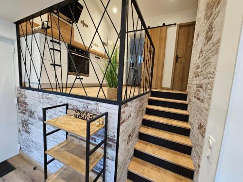 - un escalier dans une pièce dotée d'un mur en briques dans l'établissement Maison entière proche plage, à Saint-Léonard