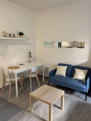 un salon avec un canapé bleu et une table dans l'établissement Grand studio centre ville Saint-Etienne, à Saint-Étienne