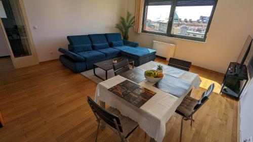 a living room with a table and a blue couch at DOWNTOWN Fiume, underground Garage within the property in Rijeka