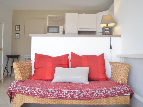 - un canapé avec des oreillers rouges et blancs dans l'établissement Coquette Villa 2P avec Jardin et Terrasse à Banyuls-sur-Mer - FR-1-225C-63, à Banyuls-sur-Mer