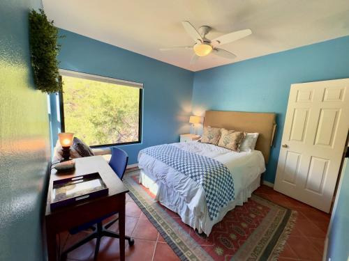 - une chambre bleue avec un lit et une fenêtre dans l'établissement Gorgeous Mountain and City Views, Pools, and Hot Tubs, à Tucson