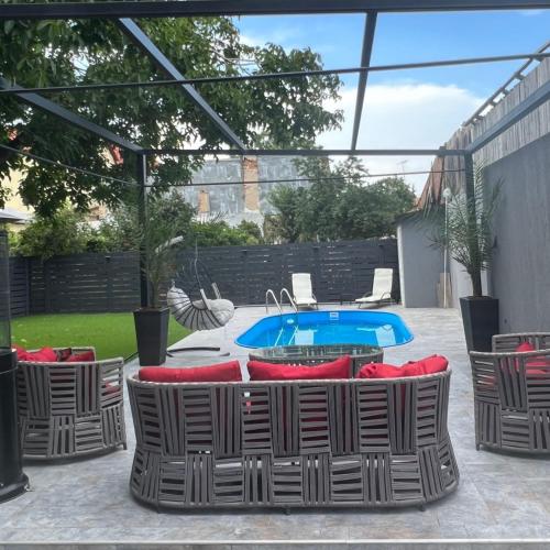 a patio with chairs and a pool in a backyard at Casa Di David in Buzău