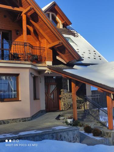 a house with a large snowboard on the roof at Penzión ORCHIDEA in Vitanová