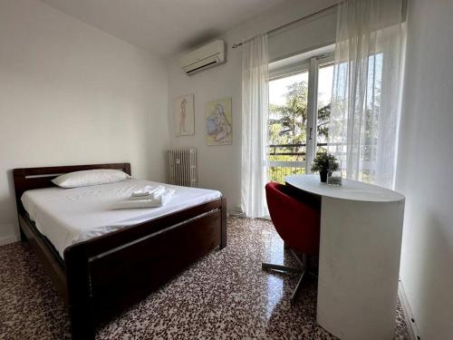 1 dormitorio con cama, mesa y ventana en Luce Apartament, en Cassina deʼ Pecchi