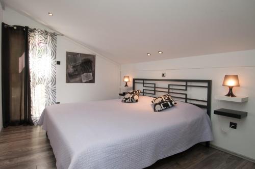 a bedroom with a white bed with two pillows on it at Apartment Gala Opatija in Opatija