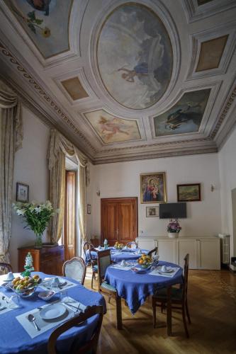 a dining room with tables with blue tablecloths at Affreschi Su Roma Luxury B&B in Rome
