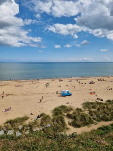 a beach with a lot of people on it at Sands Holiday Chalet Dog friendly, free wifi, swimming pool and club passes included in Scratby