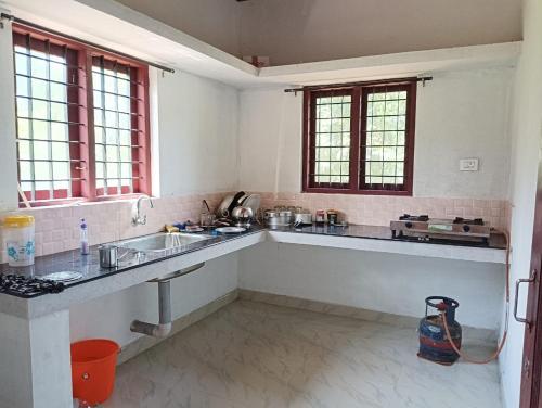 a kitchen with a sink and a counter top at Munnar Hills & Mist View in Anachal
