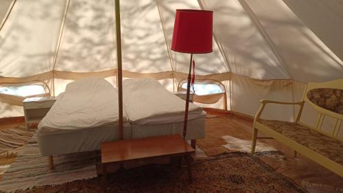 um quarto com uma tenda com uma cama e uma cadeira em Glamping tent Pielinen 